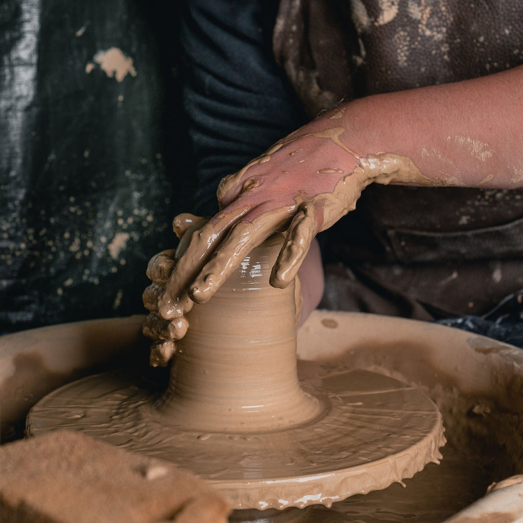 Person working with clay on a potter's wheel