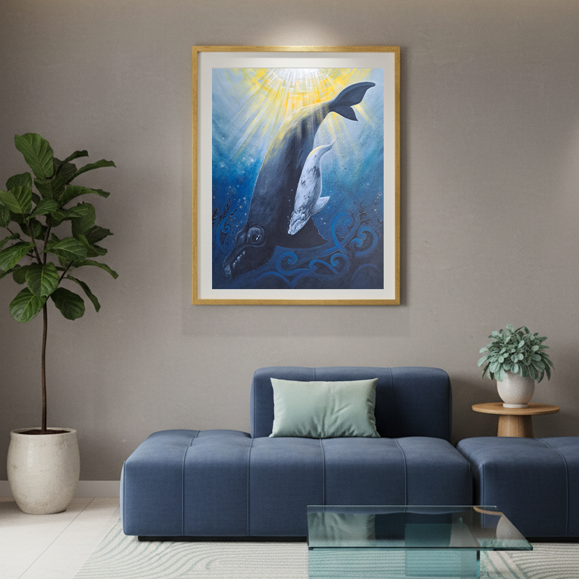 Framed artwork of whales on a wall above a blue sofa in a living room.