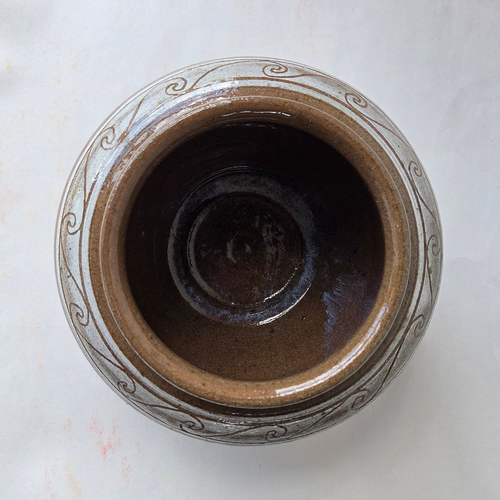 Ceramic jar with decorative patterns on a marble surface