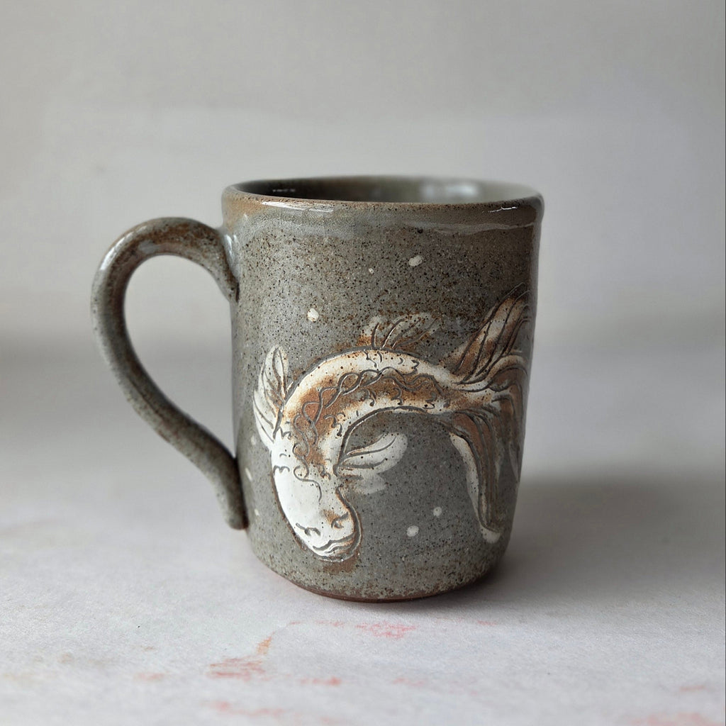 Ceramic mug with a fish design on a light gray background