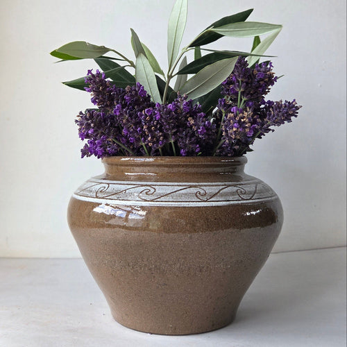 Decorative vase with lavender and olive branches on a light background